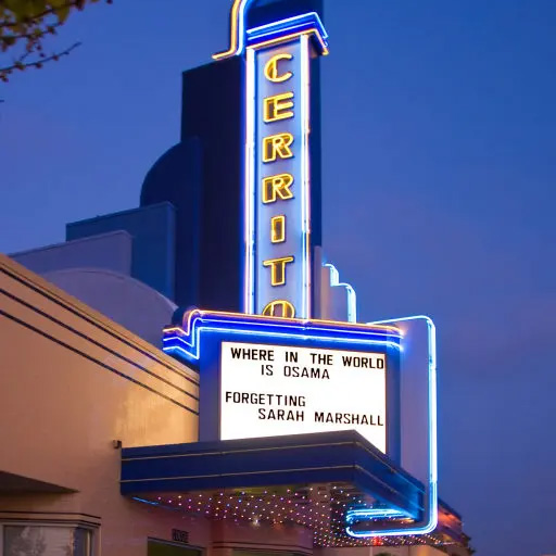 A photo of the vintage-design blade sign and marquee illuminated at night for the Rialto Cerrito Theater in El Cerrito